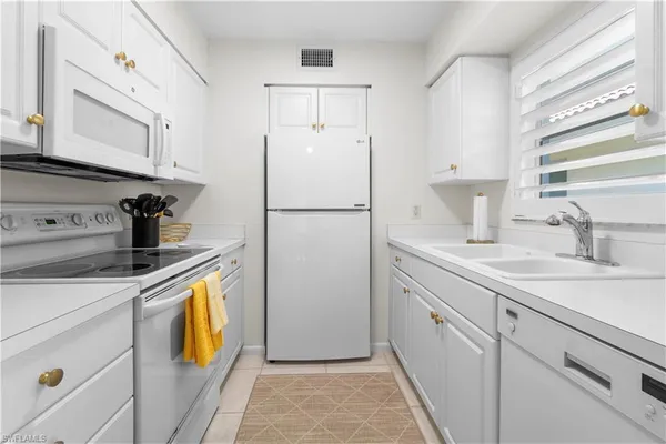 a kitchen with appliances a sink and cabinets