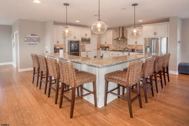 a kitchen with stainless steel appliances granite countertop a kitchen island a stove a sink a counter space and cabinets