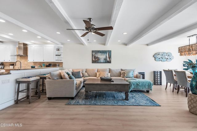 a living room with lots of furniture and kitchen view