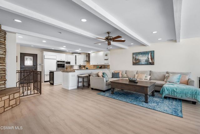 a living room with furniture and kitchen view