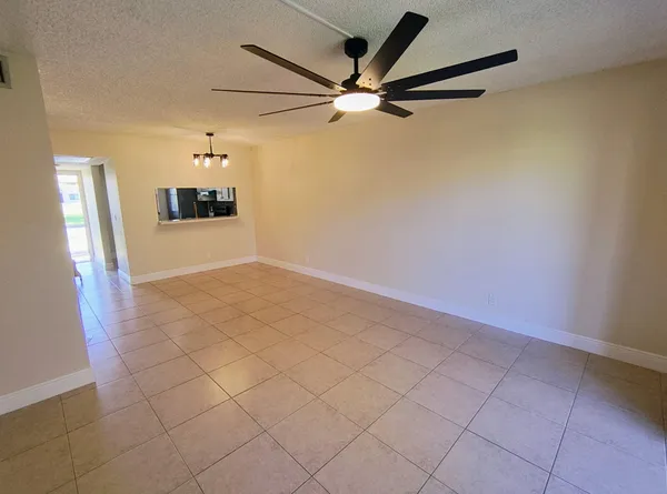 a view of a livingroom with wooden floor and a ceiling fan