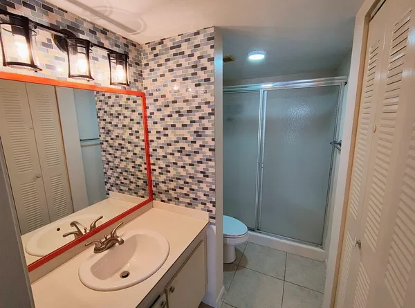 a bathroom with a sink toilet and shower