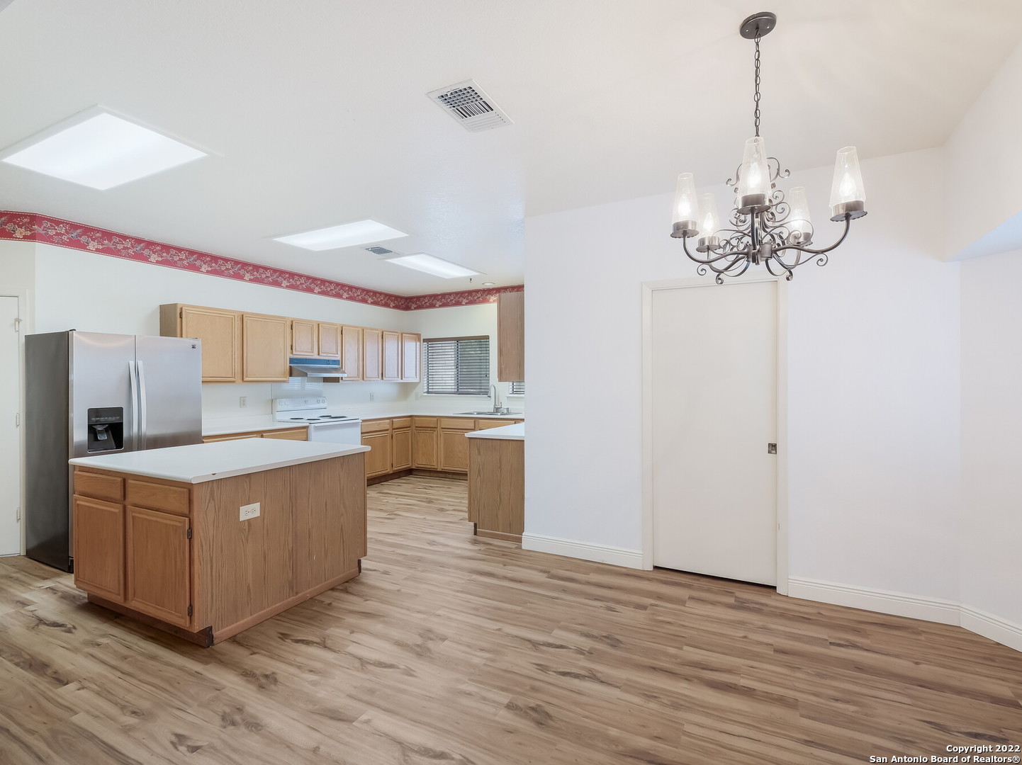 9231 Linbrooke San Antonio, TX 78250 - Photo 14 of 28 a kitchen with stainless steel appliances granite countertop a white cabinets and a chandelier