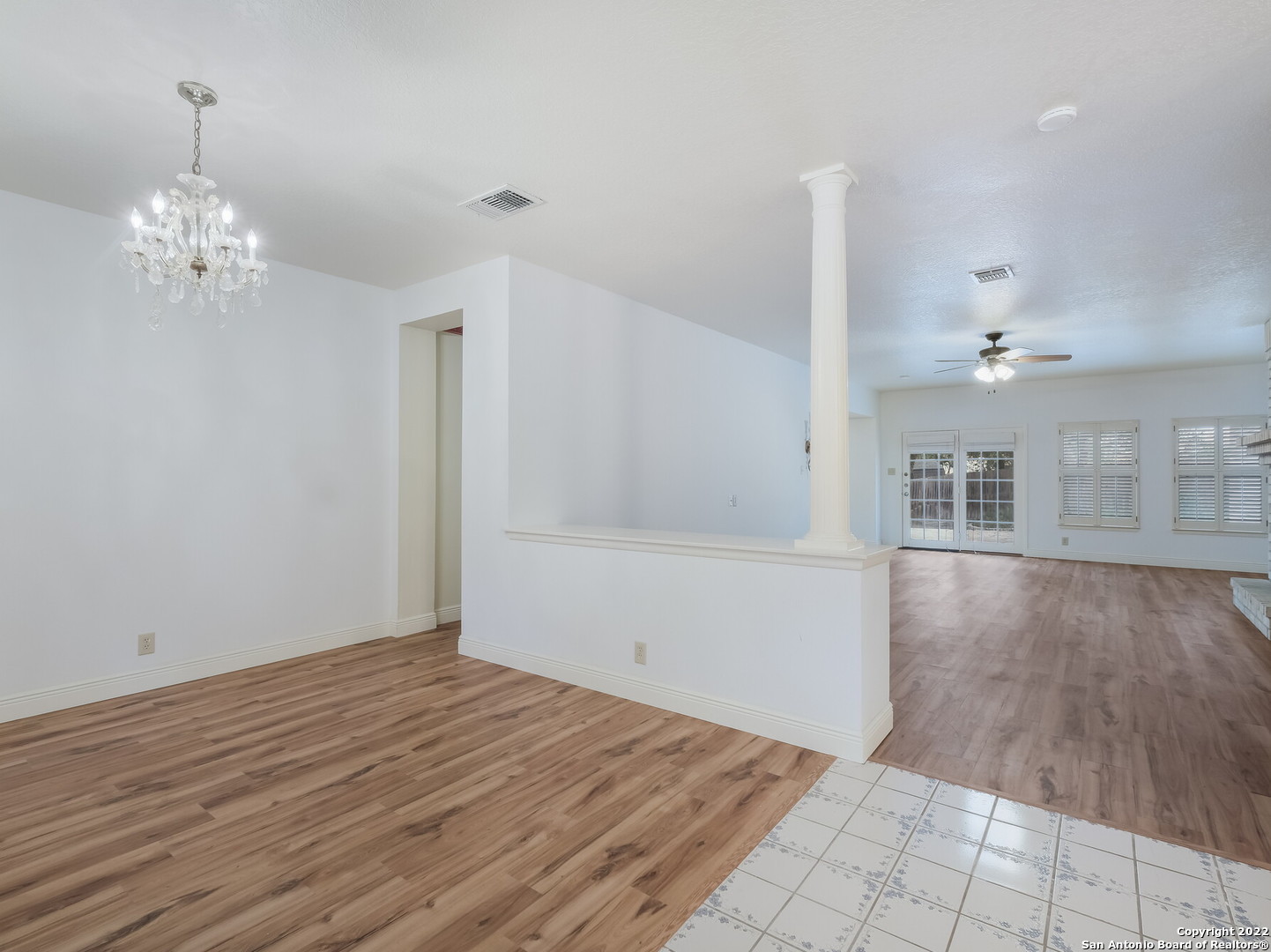 9231 Linbrooke San Antonio, TX 78250 - Photo 5 of 28 a view of an empty room with wooden floor and a kitchen