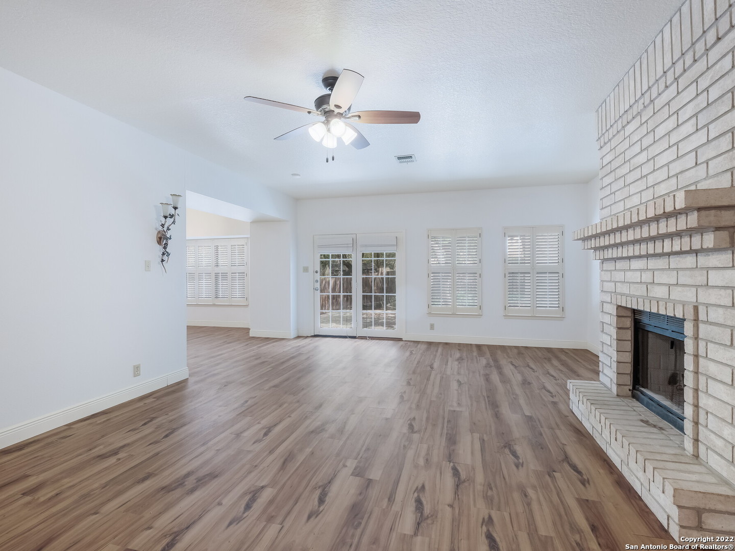 9231 Linbrooke San Antonio, TX 78250 - Photo 7 of 28 an empty room with wooden floor fireplace and windows