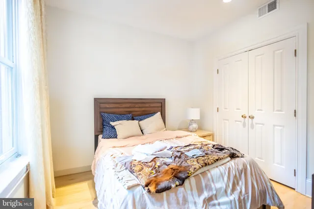 a bedroom with a bed and a painting on the wall