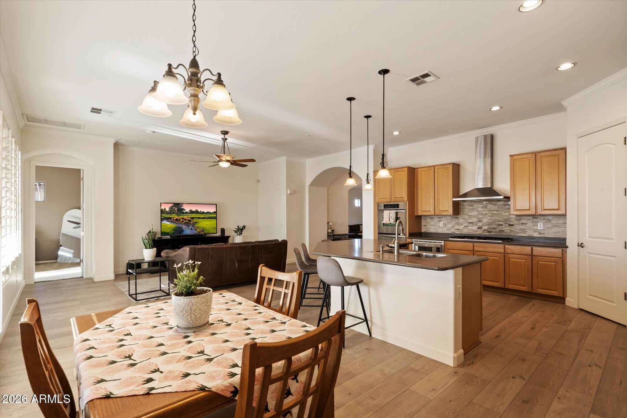3118 South Colonial Street Gilbert, AZ 85295 - Photo 21 of 38 a kitchen with stainless steel appliances kitchen island granite countertop a sink a stove a dining table and chairs
