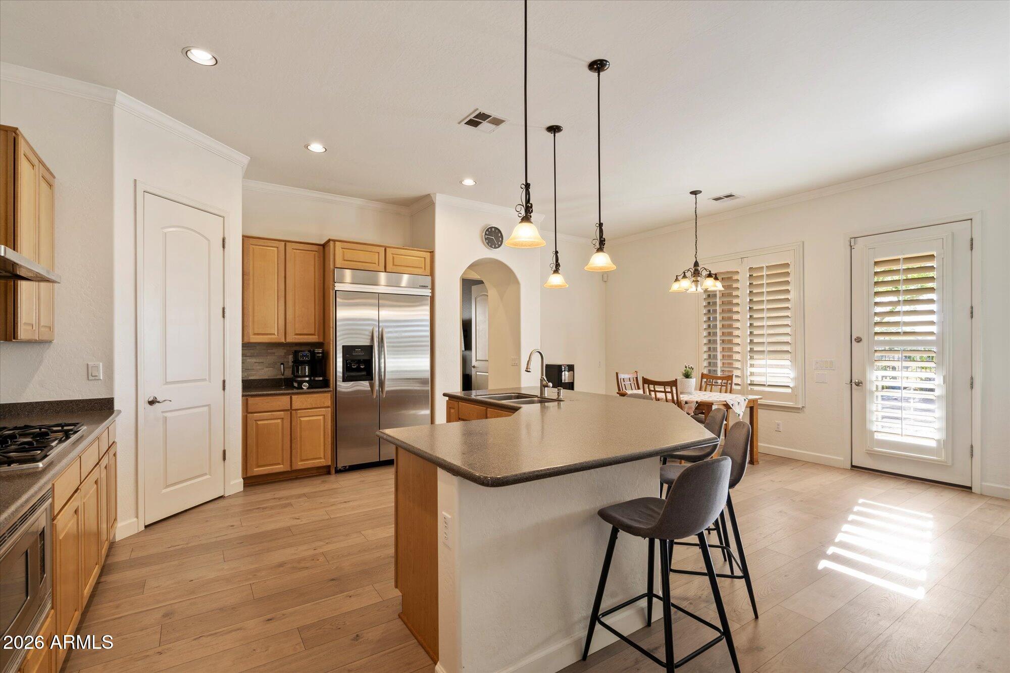 3118 South Colonial Street Gilbert, AZ 85295 - Photo 24 of 38 a kitchen with stainless steel appliances granite countertop a stove a sink dishwasher and a refrigerator with wooden floor
