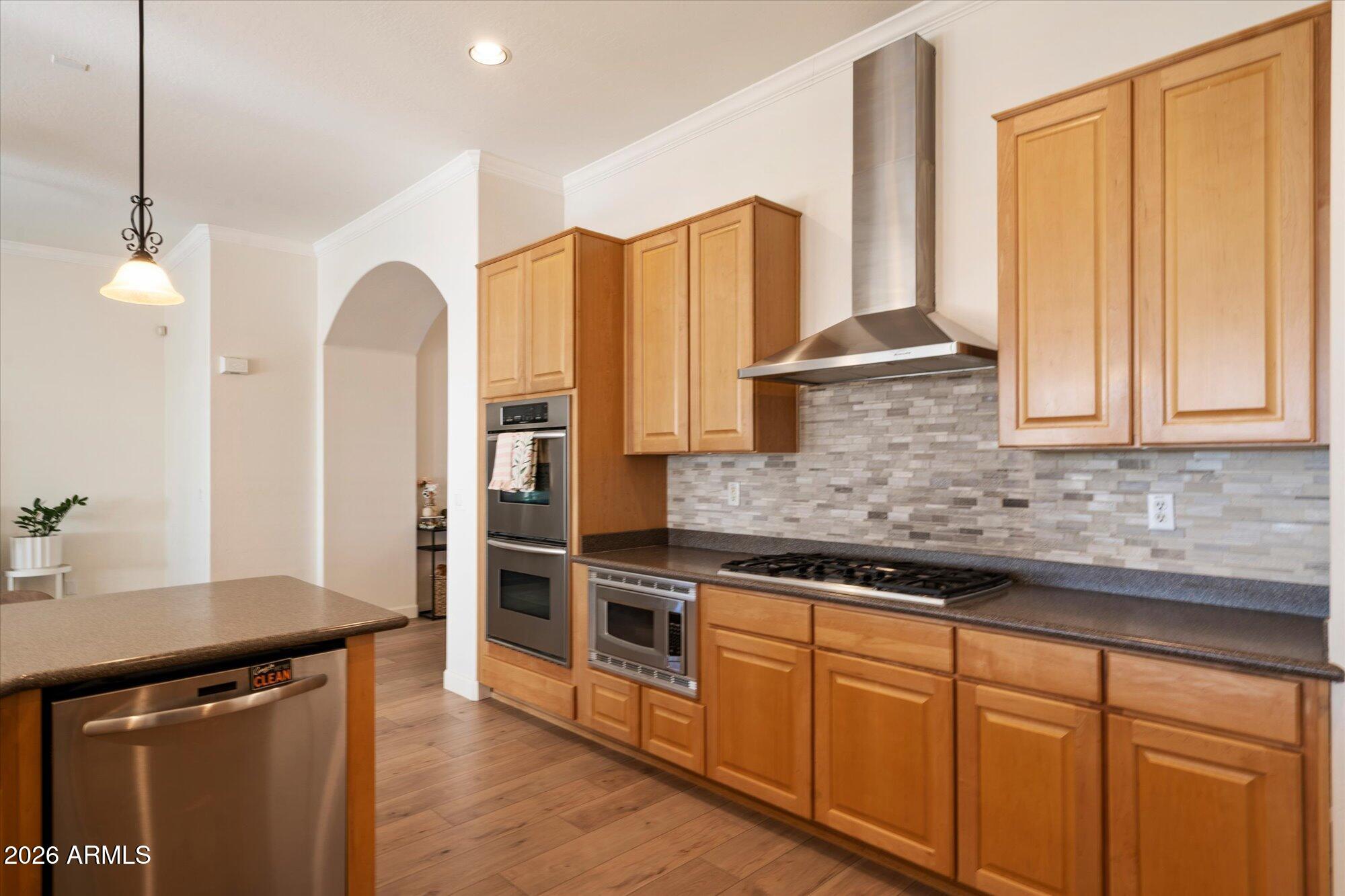 3118 South Colonial Street Gilbert, AZ 85295 - Photo 25 of 38 a kitchen with stainless steel appliances granite countertop a stove a sink and a refrigerator with wooden floor