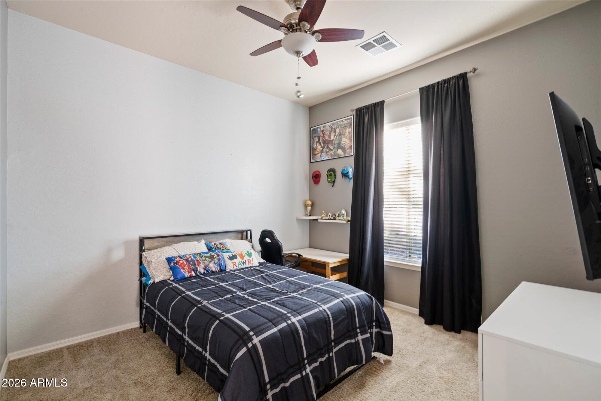 3118 South Colonial Street Gilbert, AZ 85295 - Photo 35 of 38 a bedroom with a bed and a chandelier