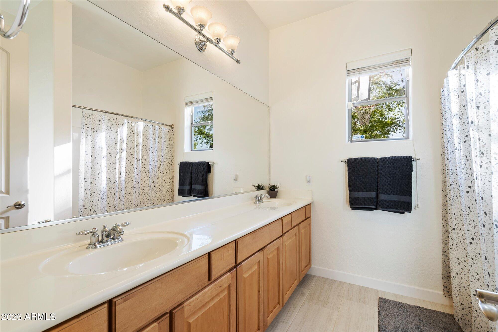 3118 South Colonial Street Gilbert, AZ 85295 - Photo 36 of 38 a bathroom with a double vanity sink mirror and shower