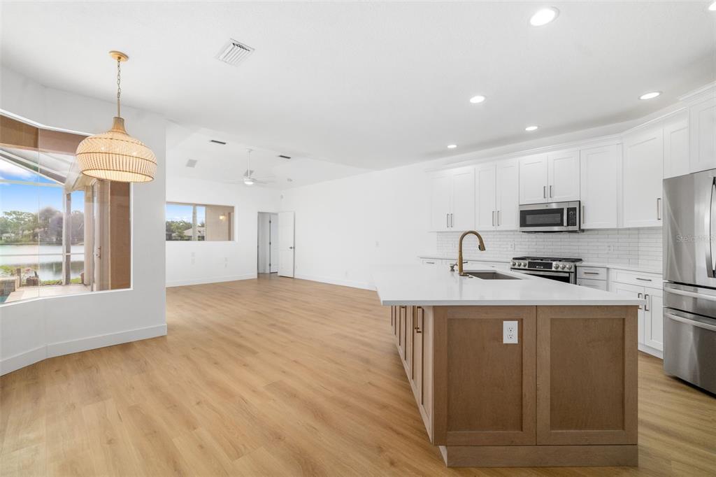 11022 Pine Lilly Place Lakewood Ranch, FL 34202 - Photo 12 of 61 a kitchen with stainless steel appliances granite countertop a refrigerator a stove top oven a sink dishwasher and a wooden cabinets