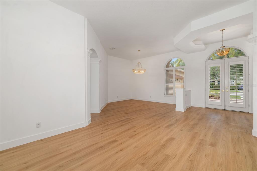 11022 Pine Lilly Place Lakewood Ranch, FL 34202 - Photo 21 of 61 a big room with wooden floor a ceiling fan and windows