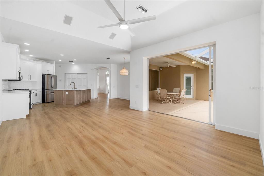 11022 Pine Lilly Place Lakewood Ranch, FL 34202 - Photo 45 of 61 a view of a living room and a kitchen with wooden floor