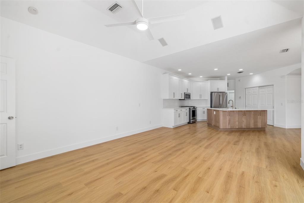 11022 Pine Lilly Place Lakewood Ranch, FL 34202 - Photo 46 of 61 a view of kitchen with kitchen island wooden floor and living room