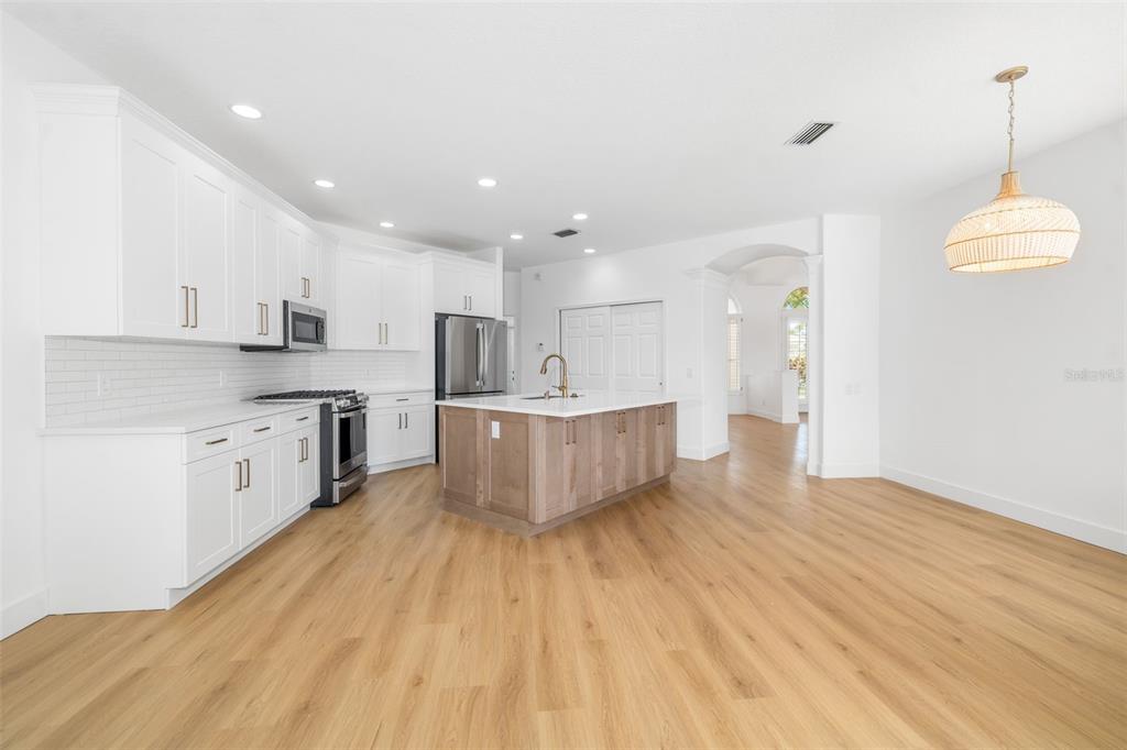 11022 Pine Lilly Place Lakewood Ranch, FL 34202 - Photo 48 of 61 a large kitchen with stainless steel appliances granite countertop a lot of cabinets and wooden floor