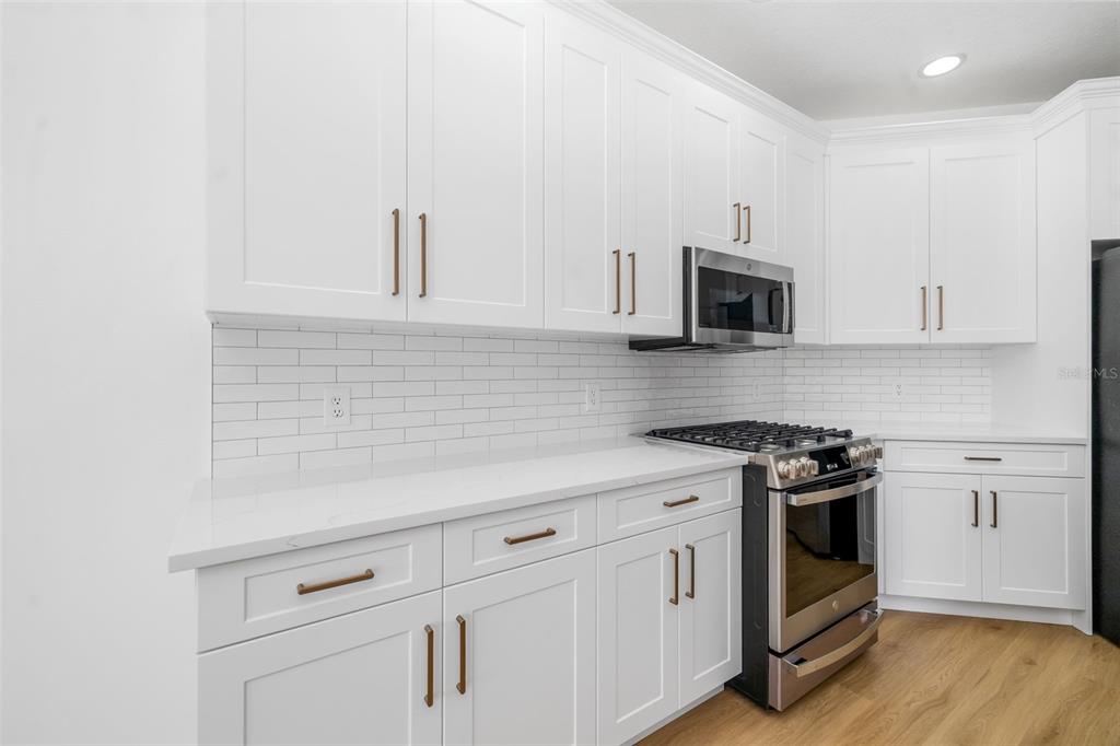 11022 Pine Lilly Place Lakewood Ranch, FL 34202 - Photo 8 of 61 a kitchen with white cabinets and appliances