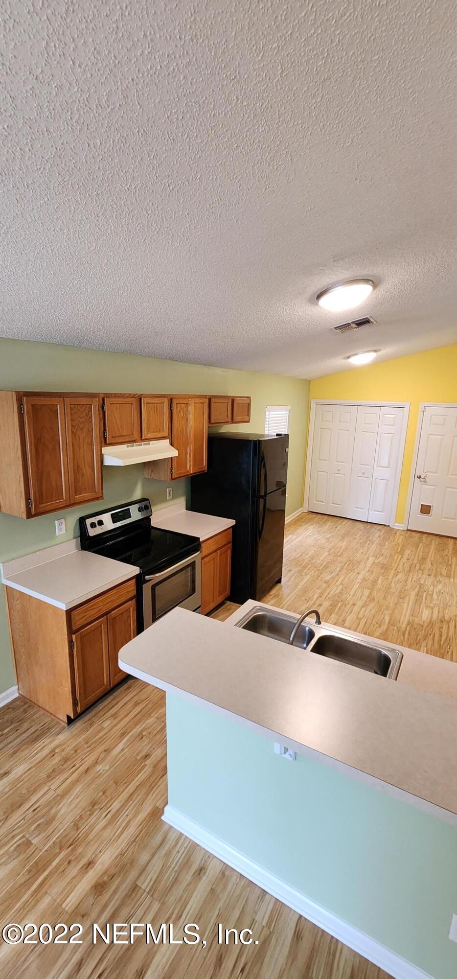 1641 Spring Oaks Lane Jacksonville, FL 32221 - Photo 9 of 40 a living room with stainless steel appliances kitchen island a stove a chimney a sink and a counter top space