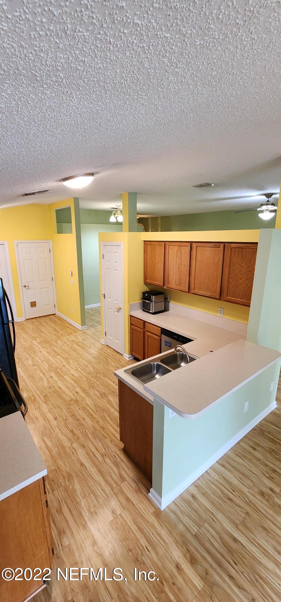 1641 Spring Oaks Lane Jacksonville, FL 32221 - Photo 10 of 40 a kitchen with stainless steel appliances kitchen island granite countertop a sink and a refrigerator