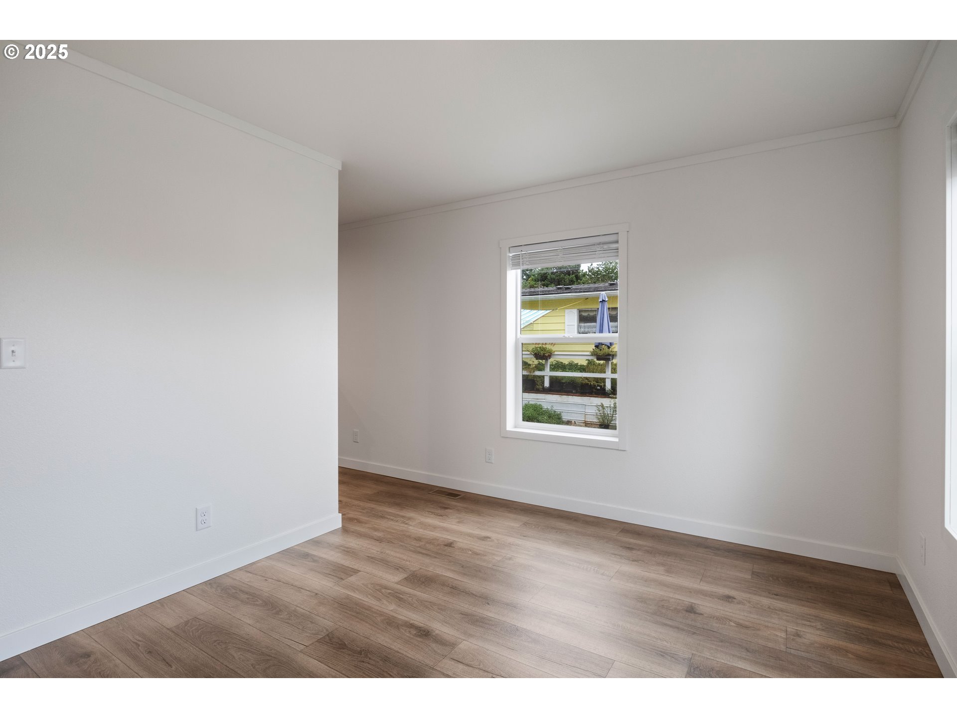 631 East Ellendale Avenue, Unit 206 Dallas, OR 97338 - Photo 11 of 30 a view of an empty room with wooden floor and a window