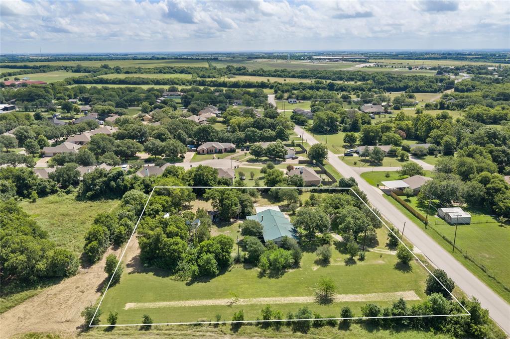 440 Williams Road Lorena, TX 76655 - Photo 5 of 19 Expansive property featuring a residence with a green metal roof, substantial surrounding green space, mature trees, and a paved road frontage