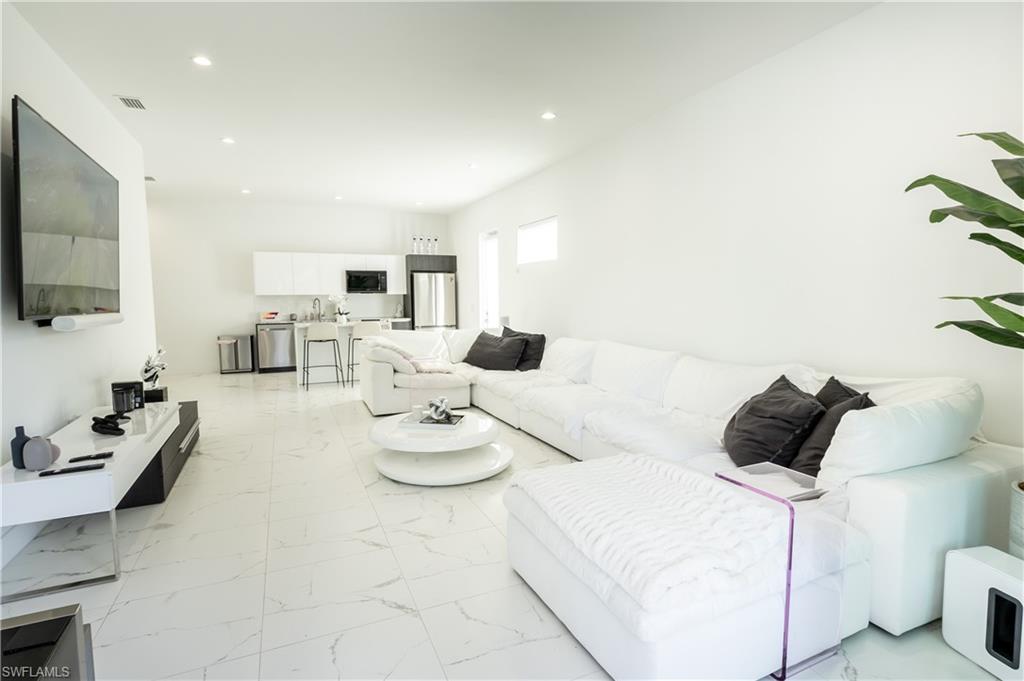 4064 Full Moon Court Naples, FL 34112 - Photo 21 of 50 a living room with furniture and a flat screen tv