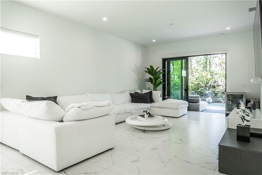 4064 Full Moon Court Naples, FL 34112 - Photo 22 of 50 a living room with furniture and a large window