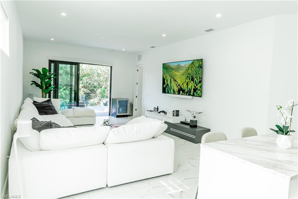4064 Full Moon Court Naples, FL 34112 - Photo 23 of 50 a living room with furniture and a flat screen tv