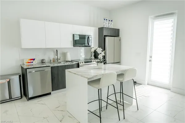 a kitchen with stainless steel appliances granite countertop a sink a stove and a granite counter tops
