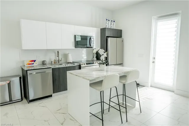 a kitchen with stainless steel appliances granite countertop a sink a stove and a granite counter tops
