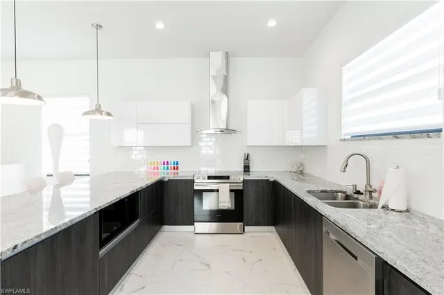 a kitchen with granite countertop a table chairs refrigerator and microwave