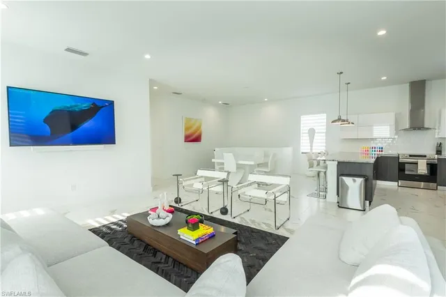 a living room with furniture and kitchen view