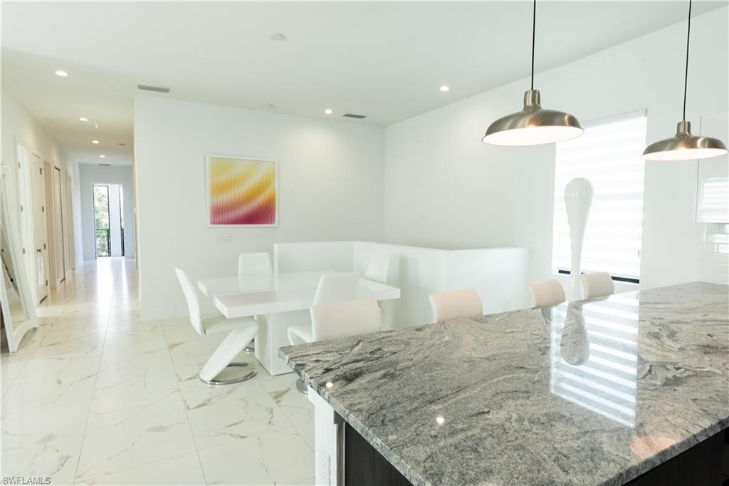 4064 Full Moon Court Naples, FL 34112 - Photo 30 of 50 a kitchen with a table and chairs