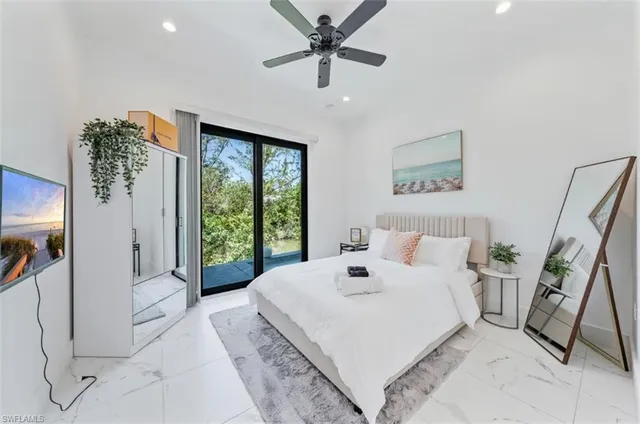 a spacious bedroom with a bed a couch and a large window