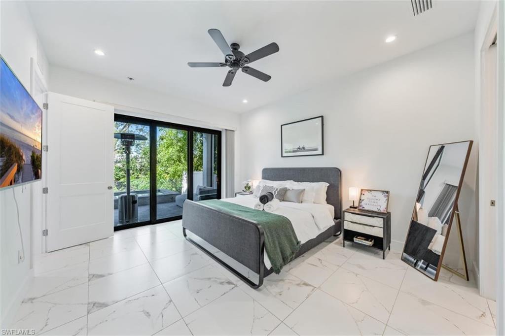 4064 Full Moon Court Naples, FL 34112 - Photo 32 of 50 a spacious bedroom with a bed a couch and a large window