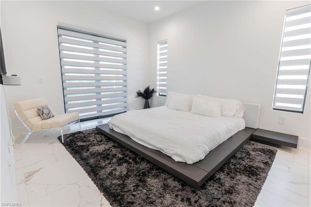 4064 Full Moon Court Naples, FL 34112 - Photo 36 of 50 a bed sitting in a bedroom next to a window