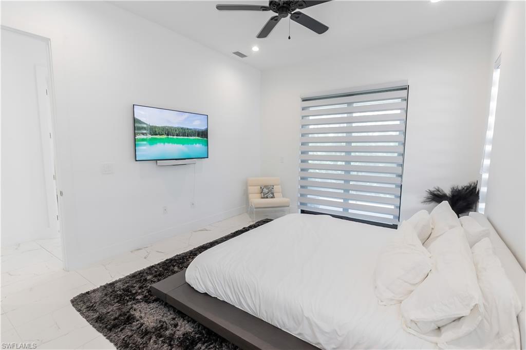 4064 Full Moon Court Naples, FL 34112 - Photo 37 of 50 a bedroom with a bed and a painting on the wall