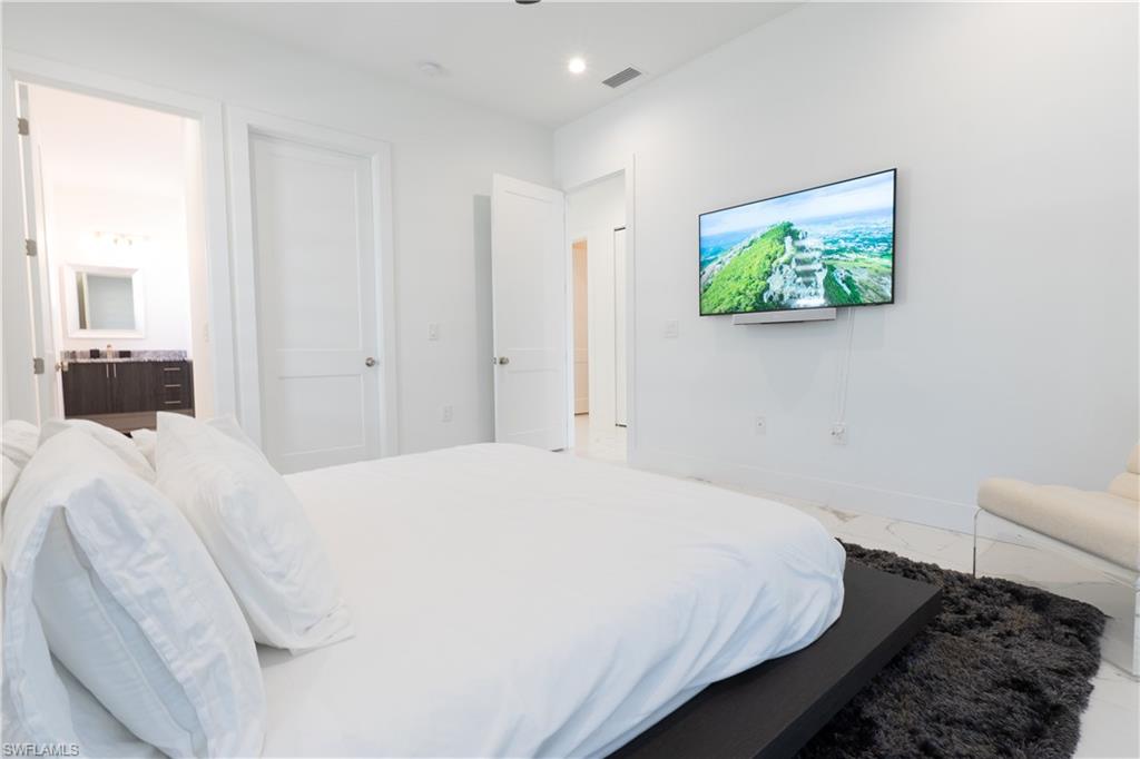 4064 Full Moon Court Naples, FL 34112 - Photo 39 of 50 a bedroom with a bed and a couch