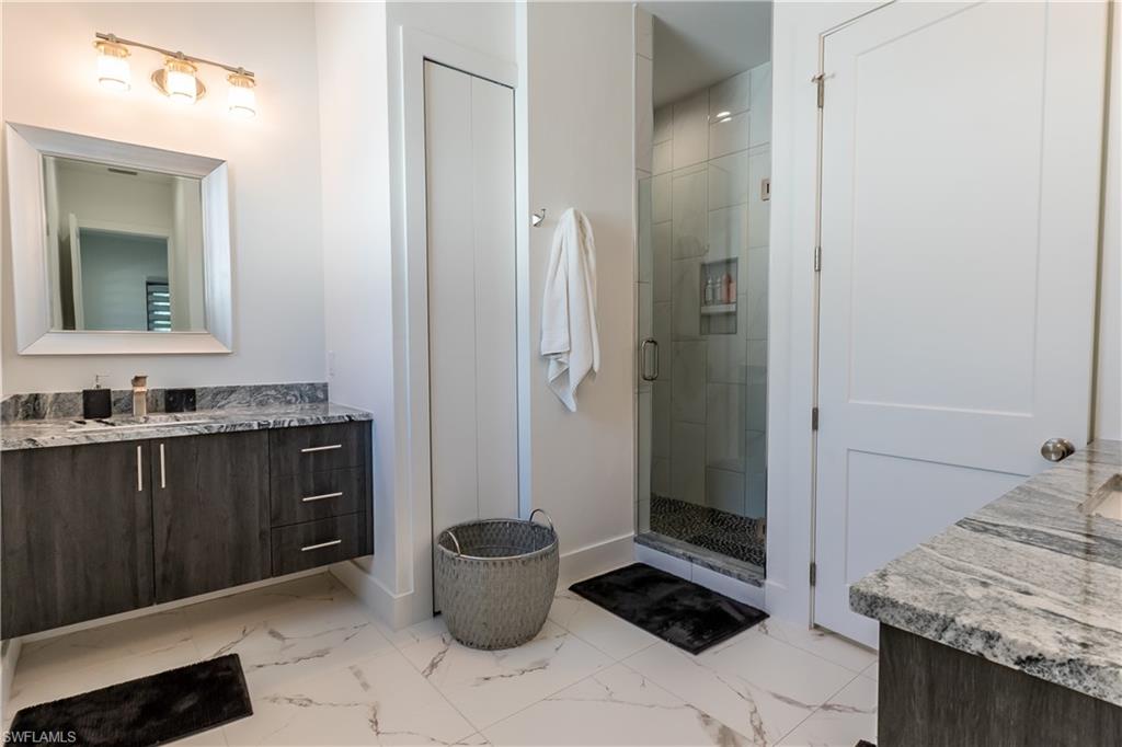 4064 Full Moon Court Naples, FL 34112 - Photo 41 of 50 a bathroom with a granite countertop sink a toilet and a mirror