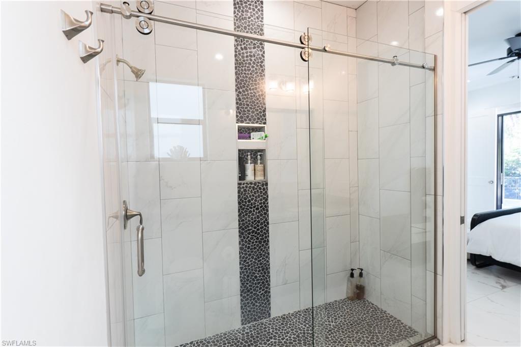 4064 Full Moon Court Naples, FL 34112 - Photo 42 of 50 a bathroom with a shower and a glass door