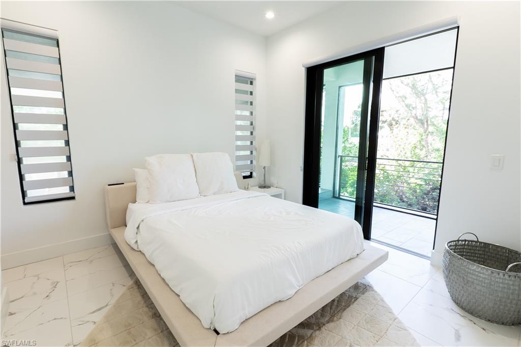 4064 Full Moon Court Naples, FL 34112 - Photo 43 of 50 a large bed sitting in a bedroom next to a window