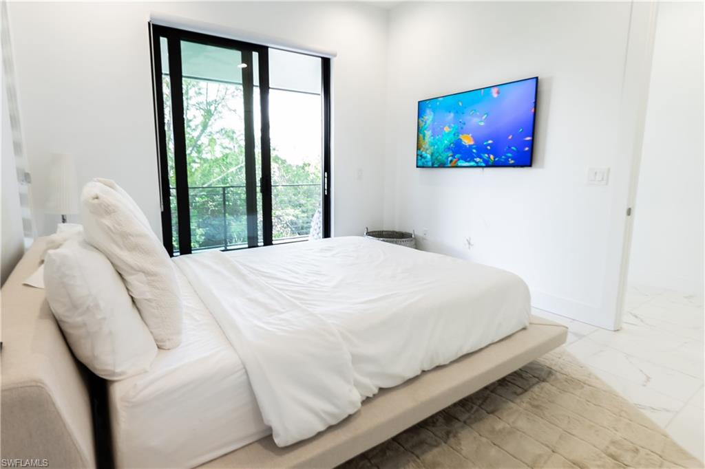 4064 Full Moon Court Naples, FL 34112 - Photo 44 of 50 a bedroom with a bed and a painting on the wall