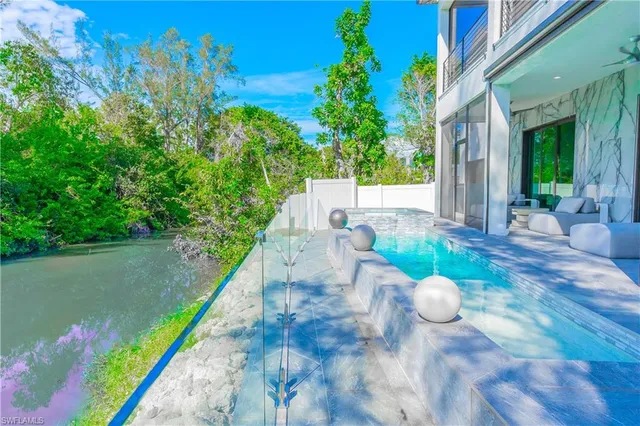 a view of a swimming pool with a patio and garden