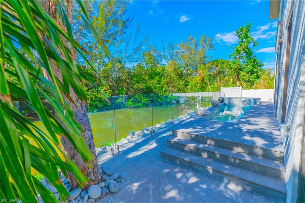 4064 Full Moon Court Naples, FL 34112 - Photo 7 of 50 a view of a yard with plants and a bench