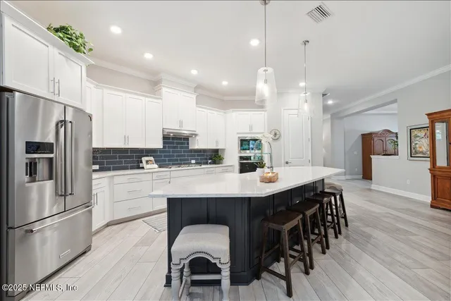 a kitchen with kitchen island wooden cabinets and refrigerator