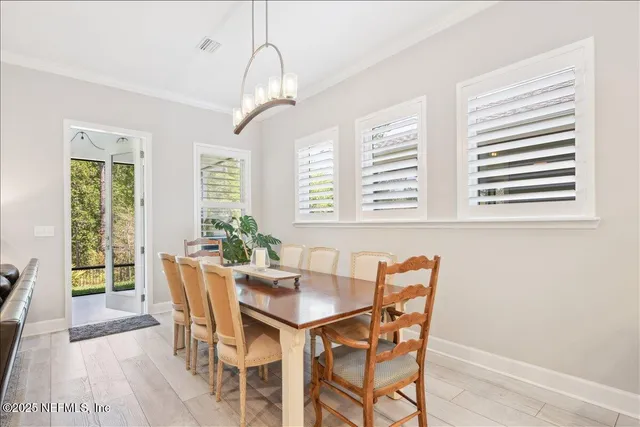 a dining room with furniture a chandelier and wooden floor