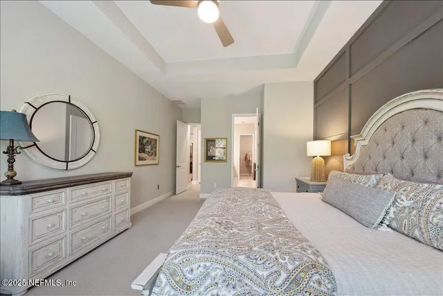 a spacious bedroom with a large bed and a chandelier