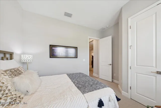 a bedroom with a bed and a painting on the wall