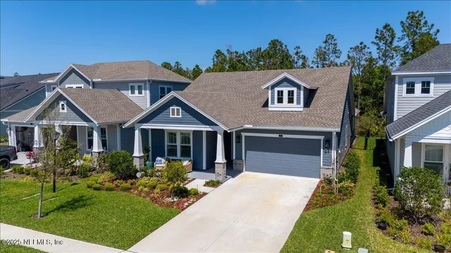 a front view of a house with a yard and potted plants