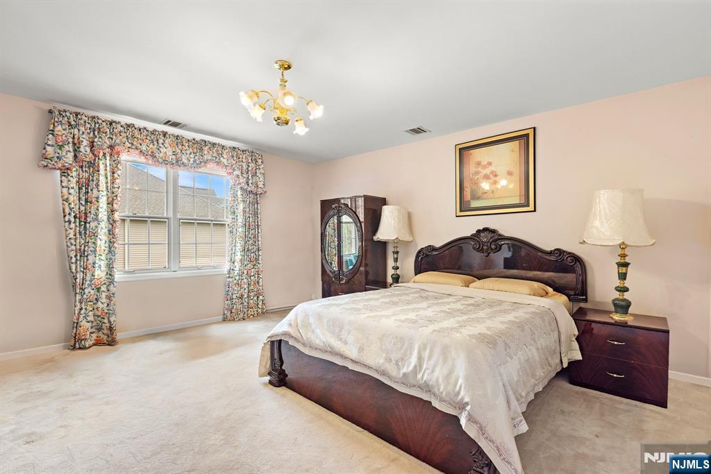 163 Rutherford Road Mahwah, NJ 07430 - Photo 24 of 33 a spacious bedroom with a bed and a chandelier